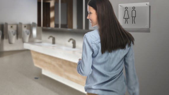 Dark-haired young woman in a public toilet